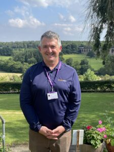 Andy Makin smiling while standing in front of the Crimple viaduct.