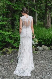 Bride poising with photo from the back showing detail on secondhand wedding dress